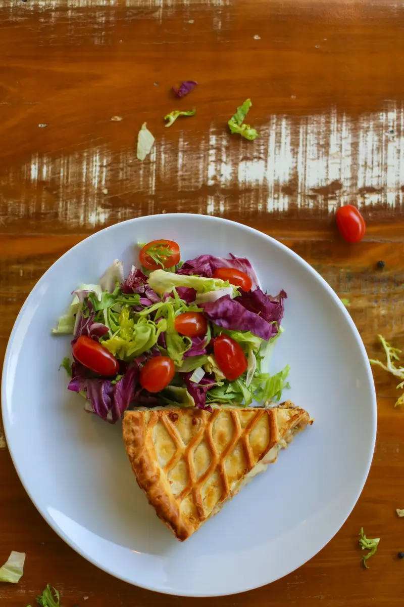Prato com fatia de torta e salada